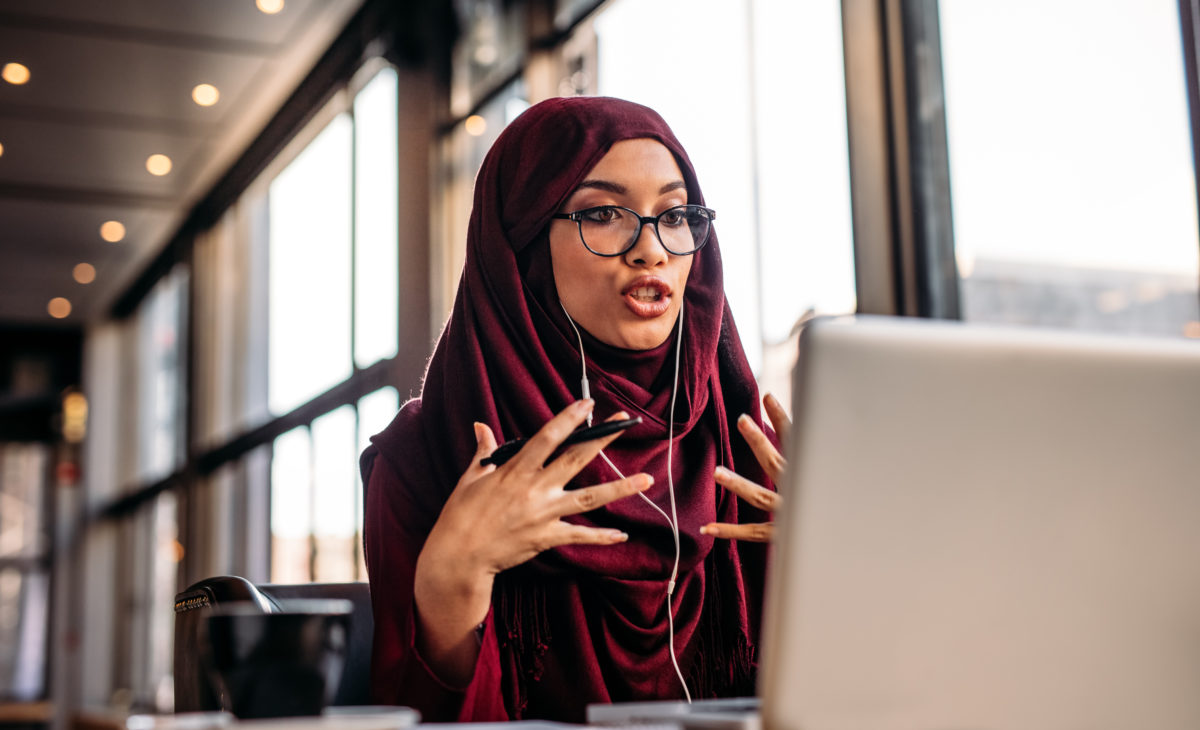 Businesswoman in hijab interacting at an online conference from her laptop